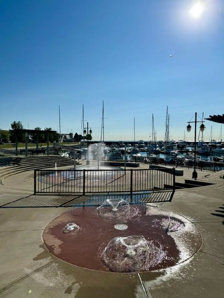 Children playing in a Kenosha splash pad with ground sprays.