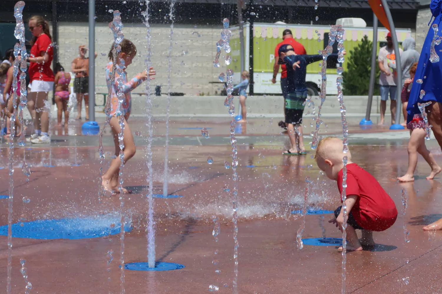 Children splashing in the water at T. Denny Sanford Splash Pad.